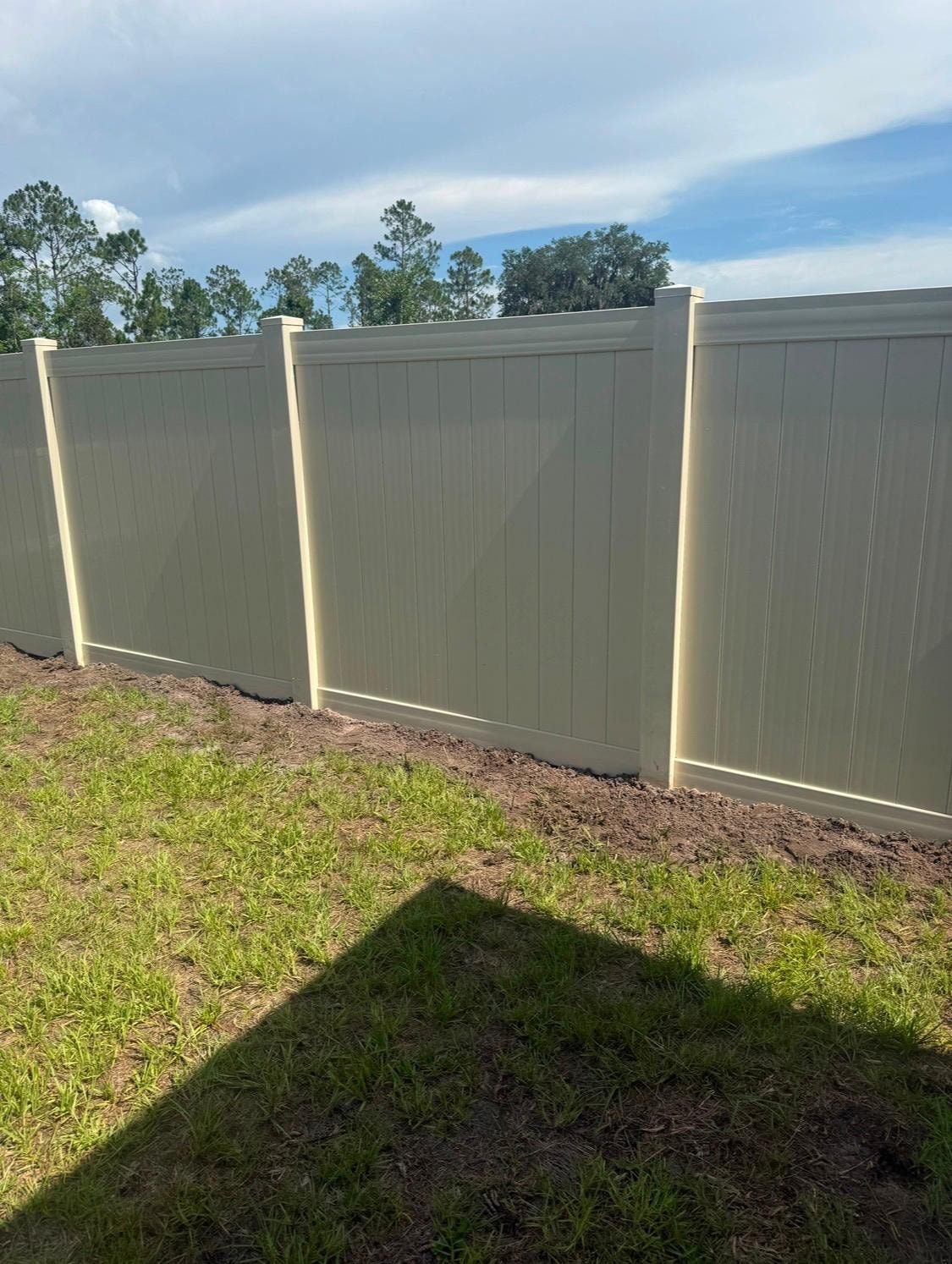Tan vinyl privacy fence installation